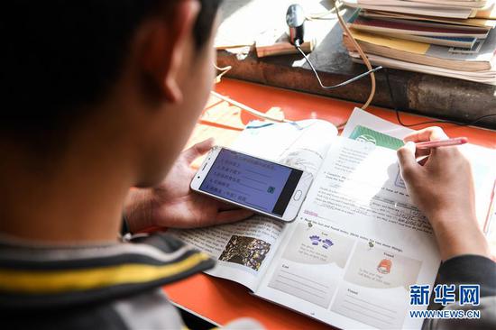  3月10日，內(nèi)蒙古準格爾旗龍口鎮(zhèn)紅樹梁村的初一學生劉進才在家中上網(wǎng)課。 新華社記者 劉磊 攝