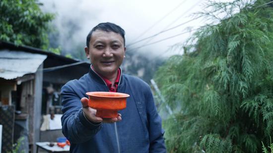  扎西巴珠展示他制作的木碗。新華網(wǎng) 旦增努布攝